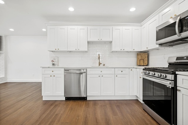 42 Chernucha Ave, Merrick, NY 11566 - kitchen with stainless steel appliances, a sink, light countertops, white cabinetry, and decorative backsplash