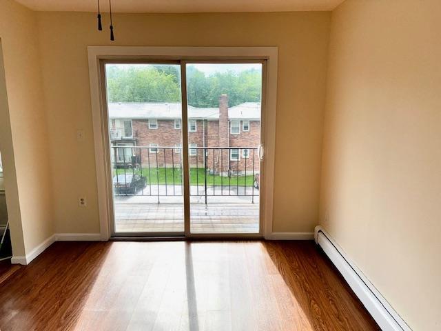 1668 Rte 9 Unit 13E, Wappingers Falls, NY 12590 - doorway with baseboard heating, dark wood finished floors, and baseboards