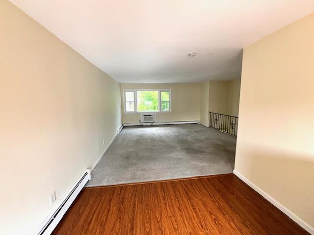 1668 Rte 9 Unit 13E, Wappingers Falls, NY 12590 - spare room with baseboards, a baseboard heating unit, and wood finished floors