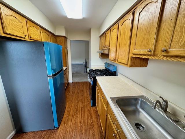 1668 Rte 9 Unit 13E, Wappingers Falls, NY 12590 - kitchen with appliances with stainless steel finishes, a sink, brown cabinets, and dark wood finished floors