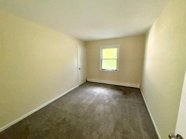 1668 Rte 9 Unit 13E, Wappingers Falls, NY 12590 - empty room with a baseboard heating unit, dark colored carpet, and baseboards