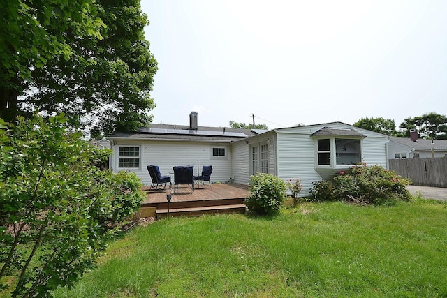 1578 N Thompson Dr, Bay Shore, NY 11706 - rear view of house featuring solar panels, a deck, and a chimney