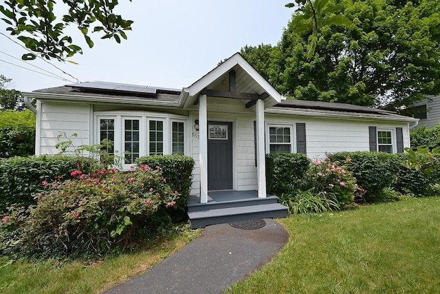 1578 N Thompson Dr, Bay Shore, NY 11706 - view of front of property featuring roof mounted solar panels and a front lawn