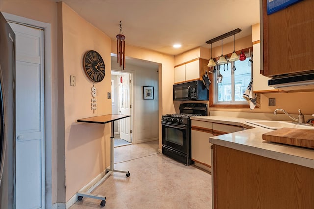 103 Fairfield Ave, Mineola, NY 11501 - kitchen featuring black appliances, a sink, baseboards, hanging light fixtures, and light countertops