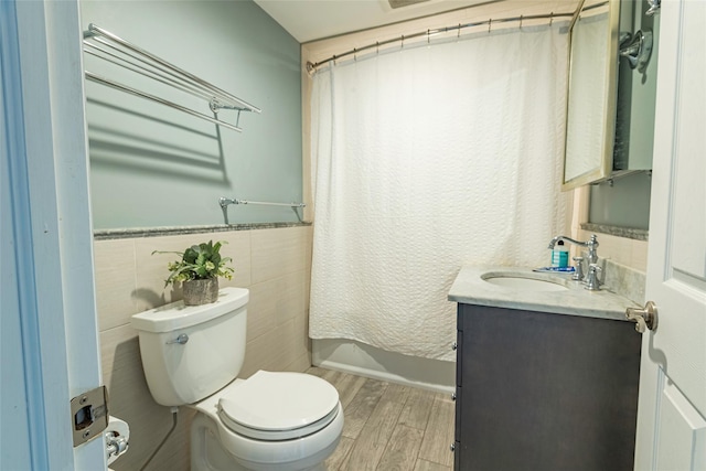 103 Fairfield Ave, Mineola, NY 11501 - full bathroom featuring vanity, toilet, wood finished floors, tile walls, and wainscoting