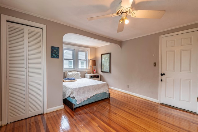 103 Fairfield Ave, Mineola, NY 11501 - bedroom with arched walkways, baseboards, hardwood / wood-style floors, crown molding, and a closet
