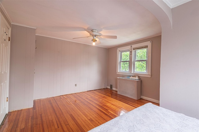 103 Fairfield Ave, Mineola, NY 11501 - unfurnished bedroom with hardwood / wood-style flooring, arched walkways, a ceiling fan, and radiator