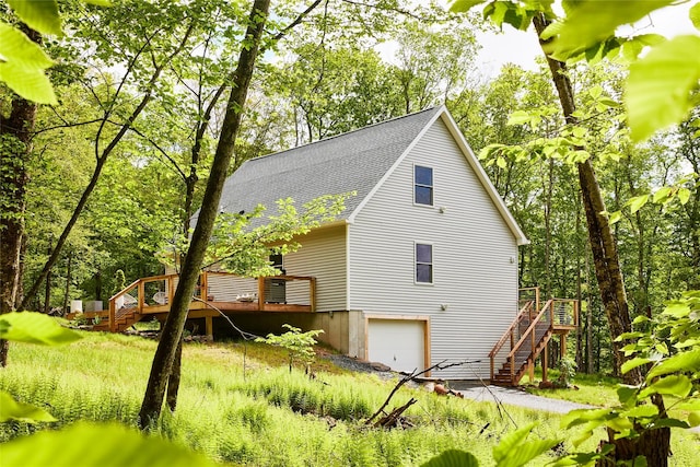 546 Willowemoc Rd, Livingston Manor, NY 12758 - view of home's exterior featuring stairway, roof with shingles, a garage, a wooden deck, and driveway