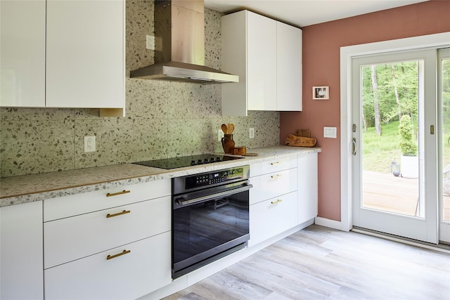 546 Willowemoc Rd, Livingston Manor, NY 12758 - kitchen featuring wall chimney range hood, black appliances, light countertops, and light wood-type flooring