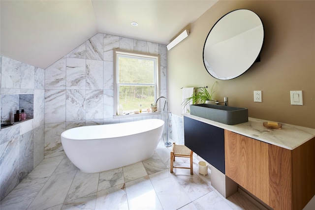 546 Willowemoc Rd, Livingston Manor, NY 12758 - bathroom featuring tile walls, vanity, a freestanding bath, marble finish flooring, and vaulted ceiling