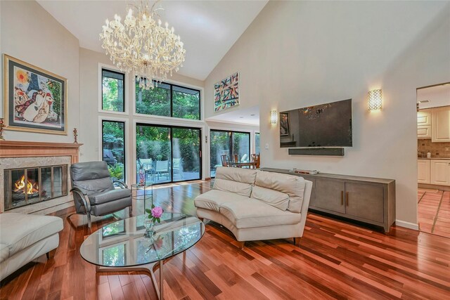 51 Eagle Chase, Woodbury, NY 11797 - living area with high vaulted ceiling, wood finished floors, a chandelier, a fireplace, and baseboards