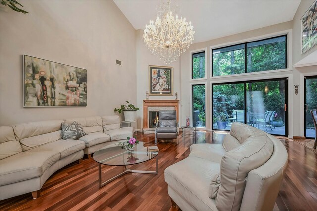 51 Eagle Chase, Woodbury, NY 11797 - living area with high vaulted ceiling, wood finished floors, a chandelier, and a premium fireplace