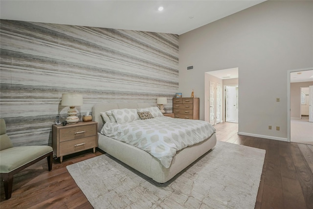 51 Eagle Chase, Woodbury, NY 11797 - bedroom with an accent wall, baseboards, dark wood-style flooring, a high ceiling, and recessed lighting