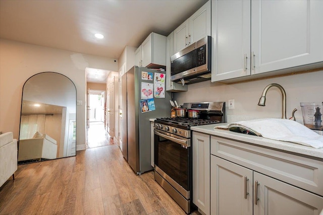 3739 Barnes Ave, Bronx, NY 10467 - kitchen with appliances with stainless steel finishes, light wood finished floors, light countertops, a sink, and recessed lighting