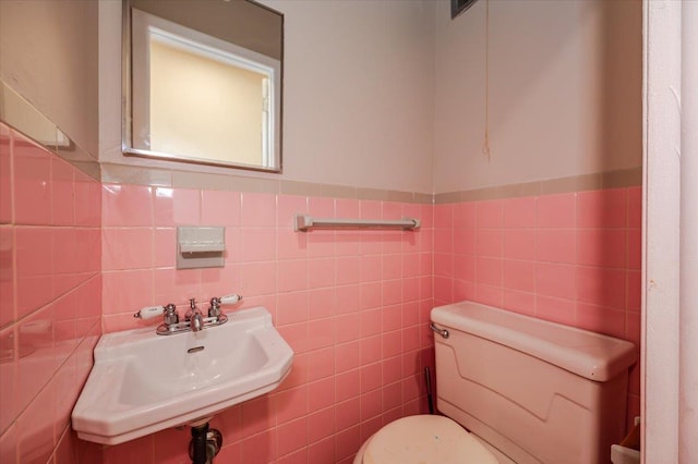 3739 Barnes Ave, Bronx, NY 10467 - half bath featuring toilet, tile walls, a wainscoted wall, and a sink