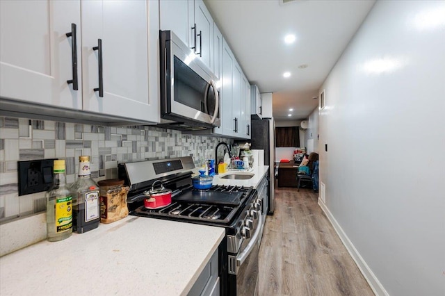 3739 Barnes Ave, Bronx, NY 10467 - kitchen featuring stainless steel appliances, a sink, light wood finished floors, baseboards, and recessed lighting