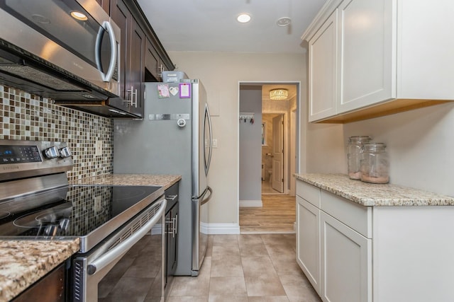 352 N State Rd Unit 2H, Briarcliff Manor, NY 10510 - kitchen with stainless steel appliances, backsplash, light stone counters, recessed lighting, and light tile patterned flooring