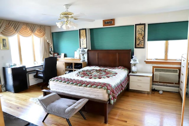 215-48 24th Ave, Bayside, NY 11360 - bedroom featuring baseboard heating, a wall unit AC, wood finished floors, freestanding refrigerator, and ceiling fan