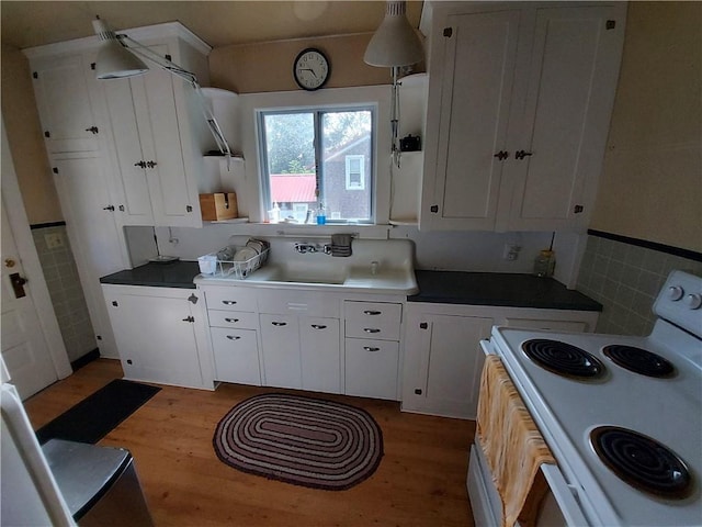 460 E Front St, Hancock, NY 13783 - kitchen featuring white electric range oven, light wood-style flooring, white cabinets, and a sink