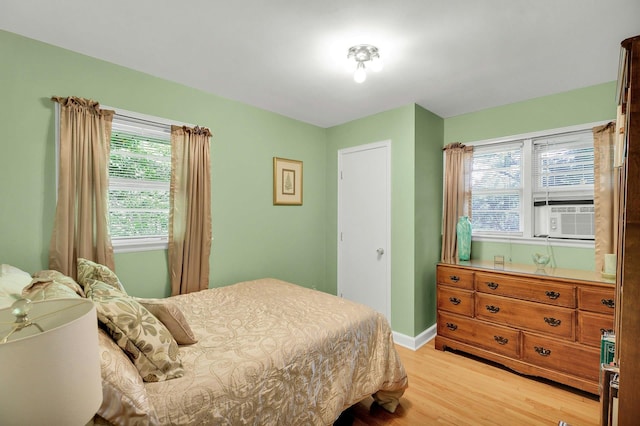 7 Woods Rd, Locust Valley, NY 11560 - bedroom with light wood-style flooring, cooling unit, multiple windows, and baseboards