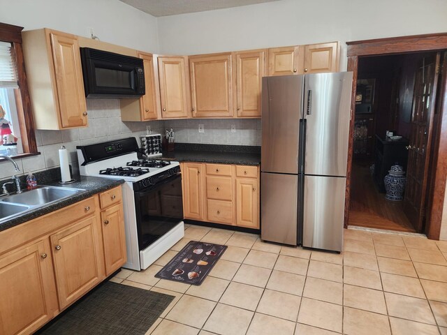 30 Royce Ave, Middletown, NY 10940 - kitchen with freestanding refrigerator, gas stove, black microwave, a sink, and dark countertops