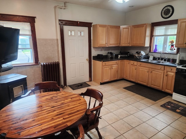 30 Royce Ave, Middletown, NY 10940 - kitchen with radiator heating unit, stove, light tile patterned floors, dark countertops, and tile walls