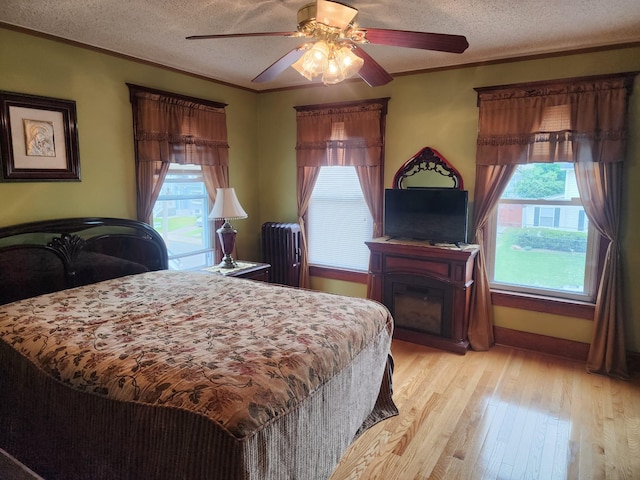 30 Royce Ave, Middletown, NY 10940 - bedroom with multiple windows, light wood-style floors, crown molding, a textured ceiling, and ceiling fan