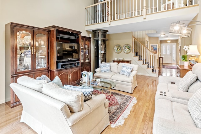 8 Lakeview Ct, Riverhead, NY 11901 - living area with stairway, a towering ceiling, light wood-type flooring, and baseboards