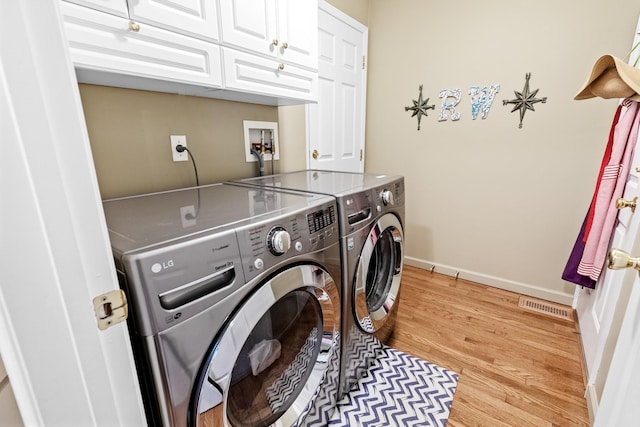8 Lakeview Ct, Riverhead, NY 11901 - laundry area with cabinet space, washer and clothes dryer, light wood-style floors, and baseboards