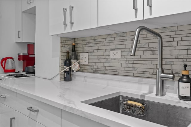 310 Riverside Dr Unit 1509, New York Manhattan, NY 10025 - kitchen with backsplash, white cabinetry, and light stone counters