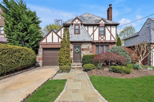 45 Henry St, Merrick, NY 11566 - tudor house featuring concrete driveway, a garage, a chimney, stucco siding, and brick siding