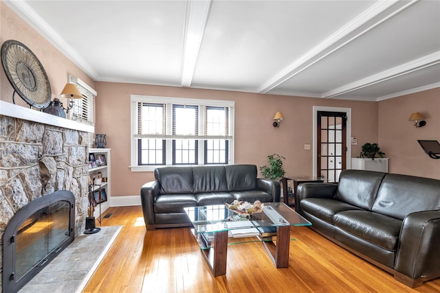 45 Henry St, Merrick, NY 11566 - living room featuring beam ceiling, a stone fireplace, wood-type flooring, baseboards, and crown molding