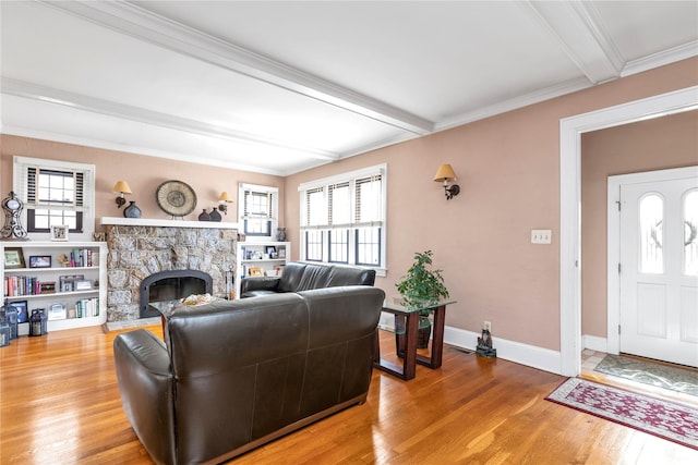 45 Henry St, Merrick, NY 11566 - living room with a stone fireplace, beam ceiling, light wood finished floors, healthy amount of natural light, and baseboards