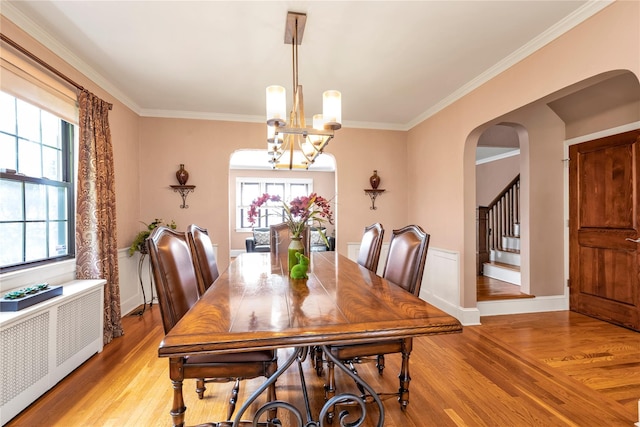 45 Henry St, Merrick, NY 11566 - dining room with light wood-type flooring, arched walkways, radiator heating unit, a chandelier, and ornamental molding