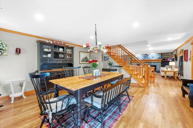 278 Gibson Hill Rd, Chester, NY 10918 - dining area with a fireplace, crown molding, stairs, a chandelier, and light wood-style flooring