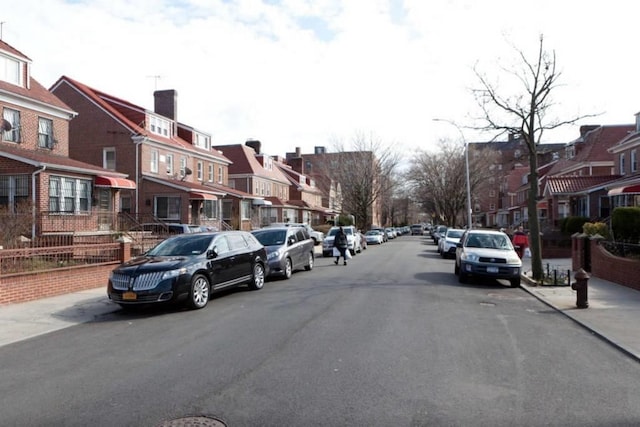 3317 87th St, Jackson Heights, NY 11372 - view of asphalt street featuring a residential view, street lights, sidewalks, and curbs