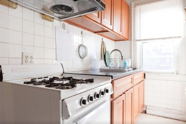 3317 87th St, Jackson Heights, NY 11372 - kitchen with white range with gas stovetop, tasteful backsplash, light countertops, and exhaust hood