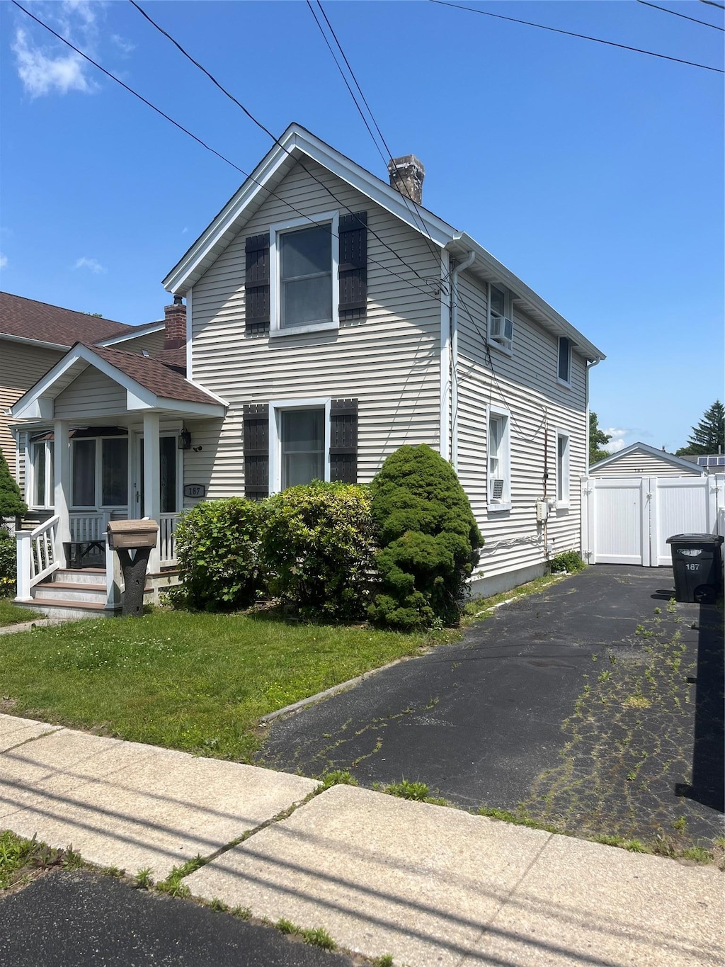 187 Smith Ave, Islip, NY 11751 - view of front facade with a porch, a gate, a detached garage, and a chimney