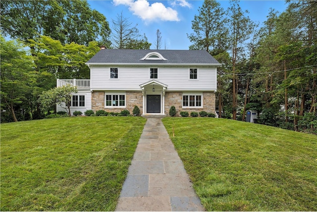 45 Fenimore Rd, New Rochelle, NY 10804 - view of front of home with stone siding, a front yard, a chimney, and a balcony