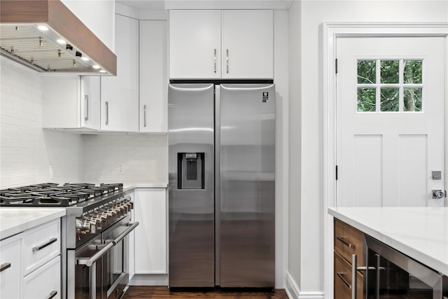 45 Fenimore Rd, New Rochelle, NY 10804 - kitchen featuring stainless steel appliances, wall chimney range hood, beverage cooler, backsplash, and white cabinets