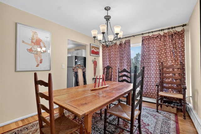 57 Panorama Dr, Patterson, NY 12563 - dining area featuring a chandelier, a baseboard heating unit, and light wood finished floors