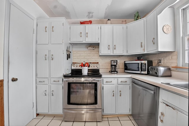 57 Panorama Dr, Patterson, NY 12563 - kitchen featuring stainless steel appliances, light tile patterned floors, light countertops, backsplash, and white cabinets
