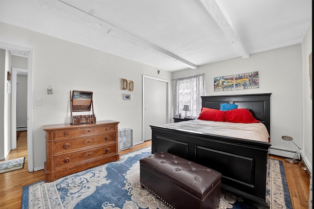57 Panorama Dr, Patterson, NY 12563 - bedroom featuring a baseboard heating unit, beam ceiling, wood finished floors, and baseboard heating