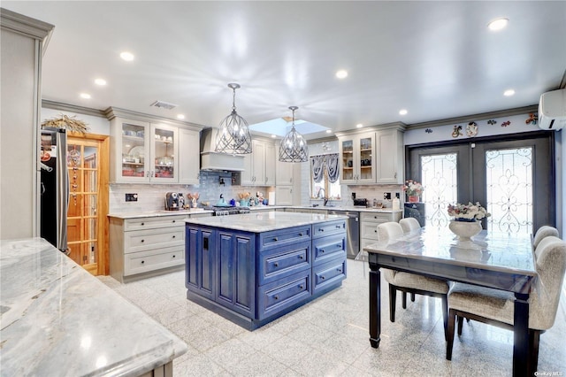 338 Cold Spring Rd, Syosset, NY 11791 - kitchen with blue cabinets, appliances with stainless steel finishes, custom range hood, ornamental molding, and decorative backsplash