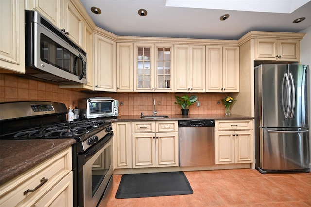206-05 Emily Rd Unit 6U, Bayside, NY 11360 - kitchen featuring appliances with stainless steel finishes, cream cabinets, backsplash, light tile patterned floors, and recessed lighting
