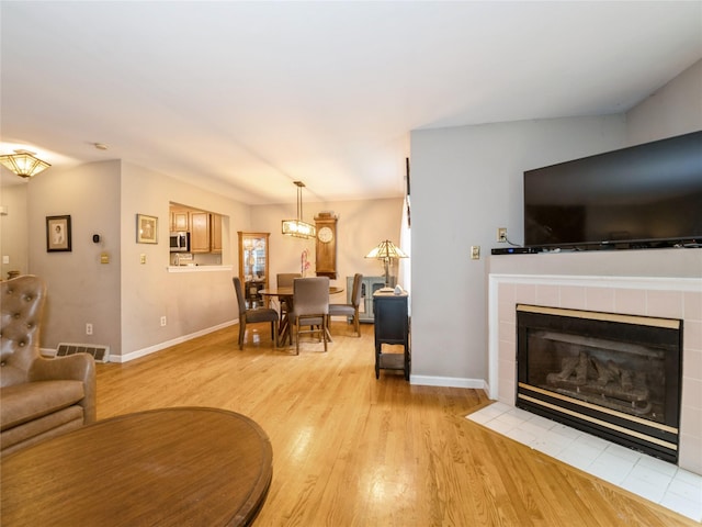 47 Muirfield Ct, Poughkeepsie, NY 12603 - living area with light wood-type flooring, baseboards, a fireplace, and a chandelier