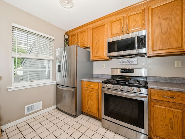 47 Muirfield Ct, Poughkeepsie, NY 12603 - kitchen featuring stainless steel appliances, brown cabinetry, baseboards, and light tile patterned floors