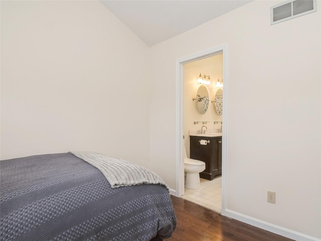 47 Muirfield Ct, Poughkeepsie, NY 12603 - bedroom featuring hardwood / wood-style floors, vaulted ceiling, a sink, baseboards, and connected bathroom