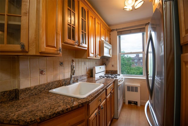 1 Georgia Ave Unit 5A, Bronxville, NY 10708 - kitchen with white appliances, a sink, radiator heating unit, and brown cabinetry