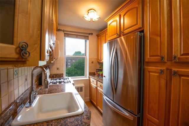 1 Georgia Ave Unit 5A, Bronxville, NY 10708 - kitchen with freestanding refrigerator, a sink, brown cabinets, and dark countertops